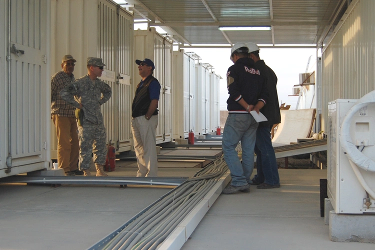 Civilian contractors and U.S. Army personnel coordinating at a forward operating base